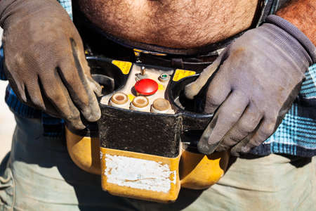 a construction worker on a construction site controls with remote control for a construction craneの写真素材