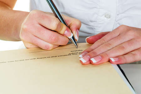 a woman signs a contract or a will with a fountain pen.の写真素材