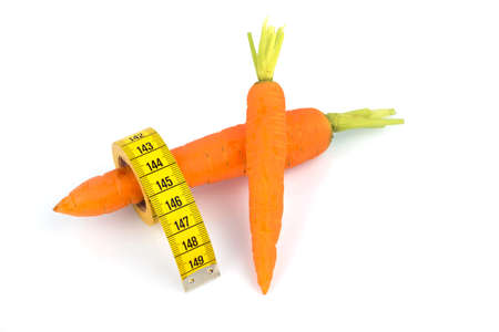 organically grown carrots with tape measure. fresh fruit and vegetables are always healthy. symbolic photo for a healthy diet.の写真素材