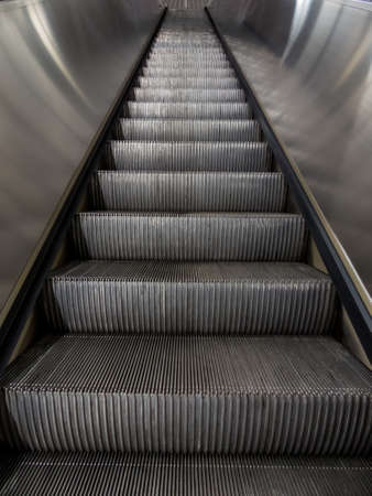 an escalator in a subway station moves up.