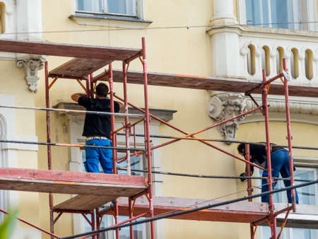 construction workers build a scaffolding at a construction siteのeditorial素材