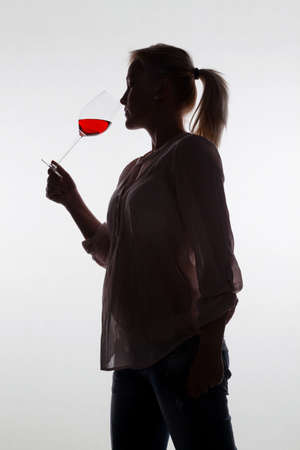 a young woman with a wine tasting  try a glass of red wine in wine glassの写真素材