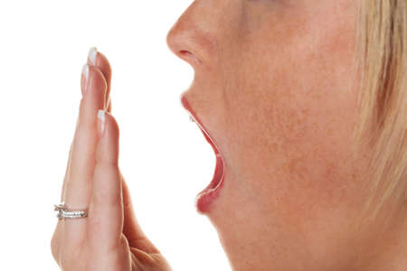 a young woman holding on while yawning hand to her mouth  fatigue and lack of sleep