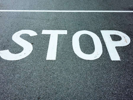 the inscription stop on a road  stopping at an intersection because of stop sign 