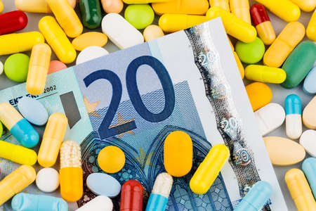 euro banknotes and tablets, symbol photo for costs of medications and health insurance.の写真素材