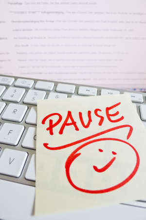 a sticky note is on the keyboard of a computer as a reminder: breakの写真素材