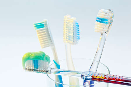several toothbrushes in a cup waiting for the teeth cleaning.の写真素材