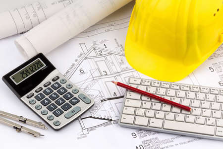 an architect's blueprint with the hard hat of a construction worker. symbolic photo for funding and planning of a new house.の写真素材