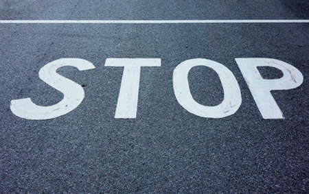 the inscription stop on a road. stopping at an intersection because of stop sign.の写真素材