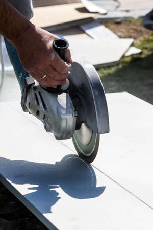 a tiler at work. cuts boards with a cut-off wheelの写真素材