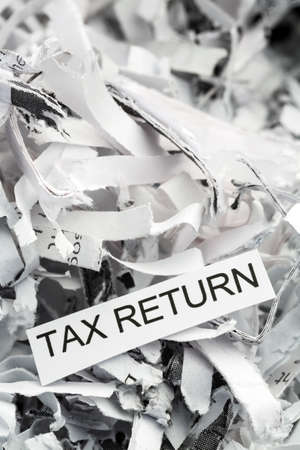 shredded paper tagged with tax return, symbol photo for data destruction, data protection and tax lawの写真素材
