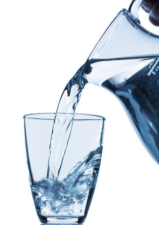 pure water is emptied into a glass of water from a pitcher. fresh drinking waterの写真素材