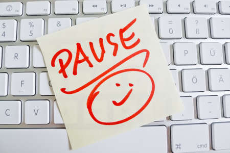 a sticky note is on the keyboard of a computer as a reminder: breakの写真素材