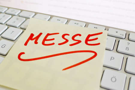 a sticky note is on the keyboard of a computer as a reminder: fairの写真素材