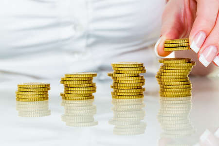 a woman stacks coins. save money for the future.の写真素材