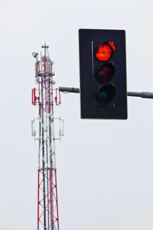 a mobile phone transmitter mast and red traffic lights. stop for network expansion.