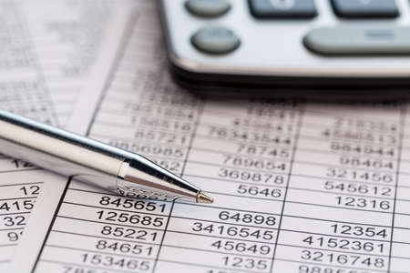 a calculator is on a balance sheet numbers are statistics photo