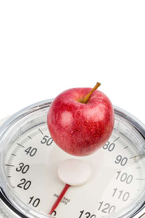 on a personal scale is an apple. symbol photo for weight loss and healthy, vitamin-rich diet.