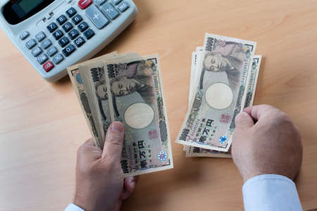 japanese yen notes. hands counting money in japanese currency