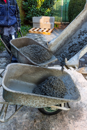 prefabricated concrete is poured from a mixer in scheib chests on a construction siteの写真素材