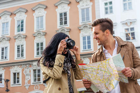 young couple with map and guide during a tour of town on vacation