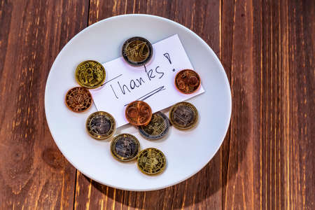 a plate of coins for tips or fee for toilets. in englishの写真素材