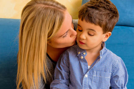 a little boy with a woman being kissedの写真素材