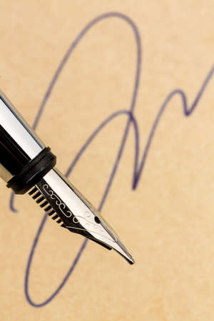 a signature and a fountain pen on yellow paper.の写真素材
