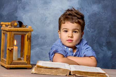 little boy with book and lanterns, symbol of education, school reform, learningの写真素材