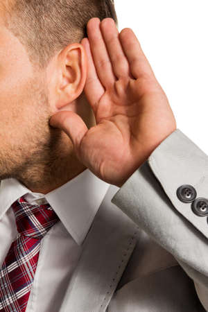 a man  holds his hand to his ear