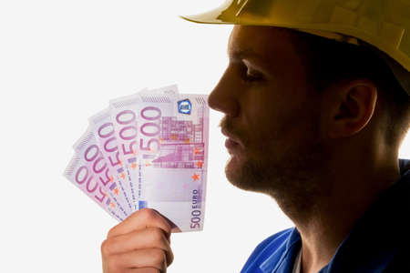 a worker in an industrial enterprise with banknotes in handの写真素材