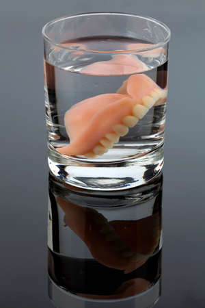 denture m water glass, symbolic photo for dentures and care