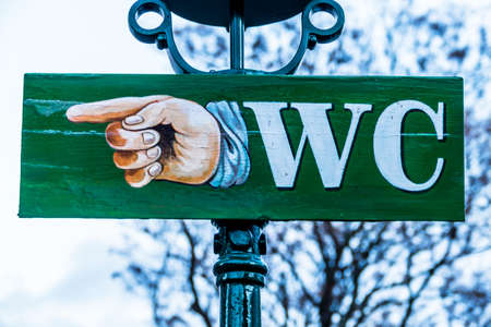 a sign points the way to the nearest toiletの写真素材