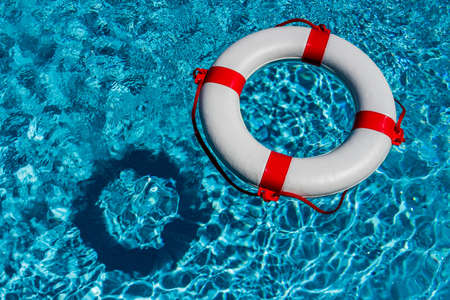 an emergency tire floating in a pool. symbolic photo for rescue and crisis management in the financial crisis and banking crisis.の写真素材