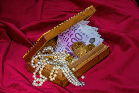 gold coins and bars with decorations on red velvet. photo icon for wealth, luxury, wealth tax.の写真素材