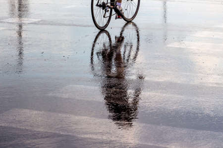 cyclists in the rain, a symbol of bad weather, accident risk, mobility, fitnessの写真素材