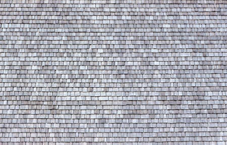an old house on a mountain pasture in austria was covered with shingles. wooden roof shinglesの写真素材