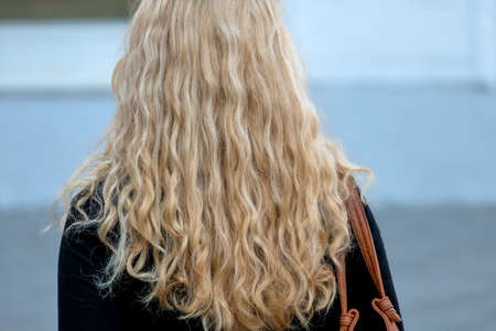 woman with long blond hair, a symbol of femininity, anonymityの写真素材