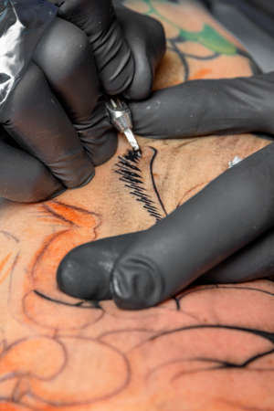 A tattoo artist at work. tattoos are very fashionable among young peopleのeditorial素材