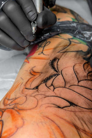 A tattoo artist at work. tattoos are very fashionable among young peopleのeditorial素材
