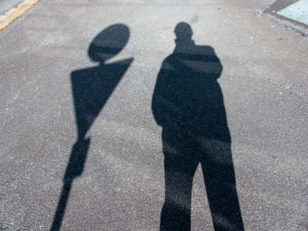 the shadow of a man on a sidewalk. anonymity of the big city.の写真素材