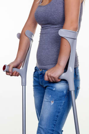 a young woman with crutches. symbolic photo for accidents, domestic accidents and insurance.の写真素材