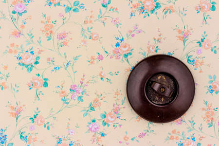 an old wallpaper with light switch. symbolic photo for renovation and remodel.の写真素材