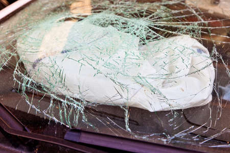 a broken windshield and an airbag during an accident ausglöster carの写真素材