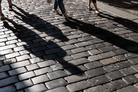 shadows of people on a pavement