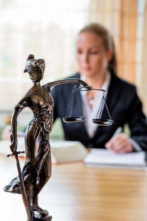 businesswoman sitting in an office. symbol photo for managers, self or lawyer.の写真素材