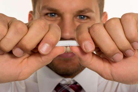 a man wants to quit smoking and breaks his last cigaretteの写真素材