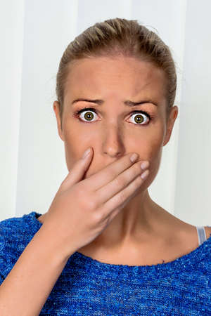 a young woman is afraid and looks scaredの写真素材