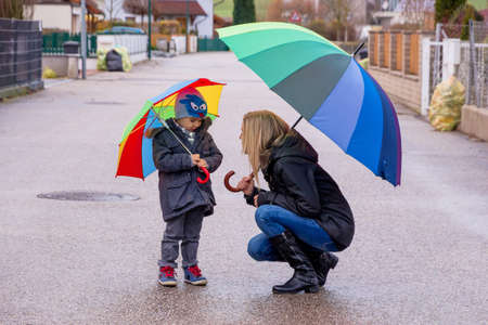 mother and child with umbrella, a symbol of solidarity, assistance, bailout, bailout,の写真素材