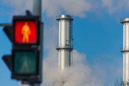 chimney of an industrial company and a red light. symbolic photo for environmental protection and ozone.の写真素材